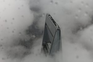 Ariel photograph of high rise building pushing through clouds