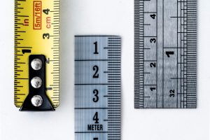 Yellow measuring tape and rulers on white background